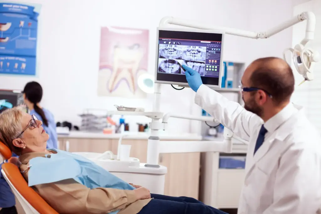 Dentist discussing dental implant options with a patient using a model during a relaxed consultation.